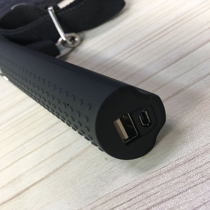 Black power bank with two USB ports on a light wooden surface
